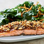 Eat to Beat Diabetes: Your Carb Guide for Healthy Blood Sugar Grilled salmon fillet topped with nuts and herbs on a white plate, served with a fresh green salad and carrot shreds.