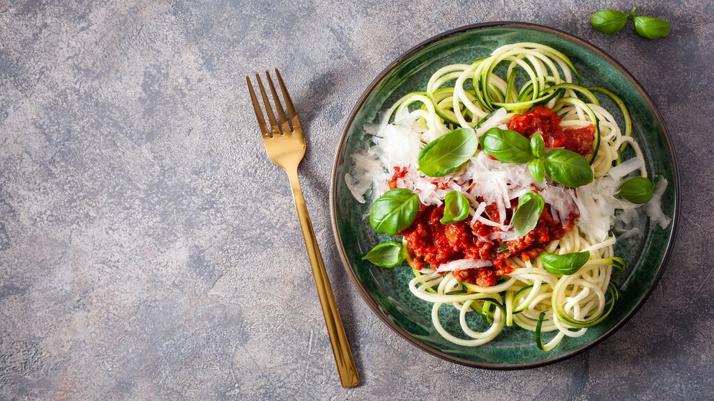 Zucchini noodles topped with marinara sauce and basil.