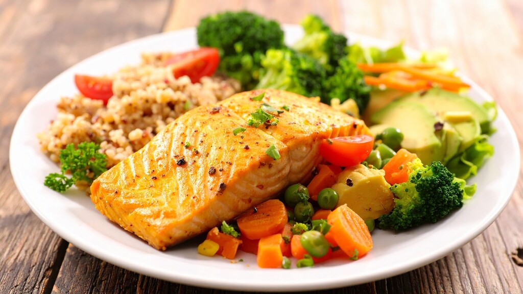 Salmon served with vegetables, avocado, and grains.