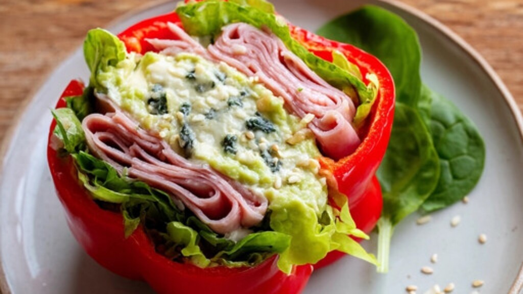 Bell pepper sandwich filled with greens, deli meat, and creamy spread.