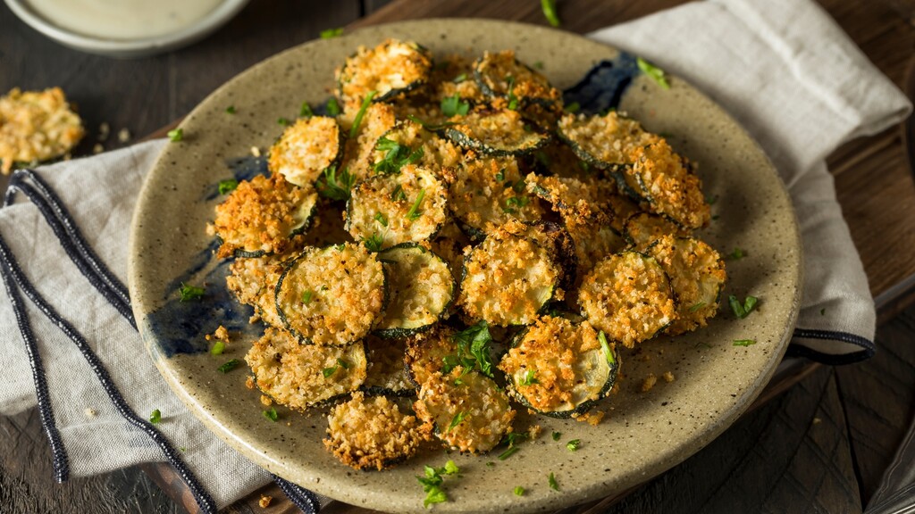 Crispy baked zucchini chips on a plate.