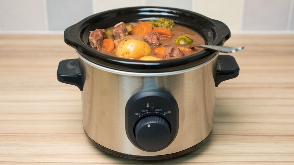 Slow cooker filled with stew and vegetables.