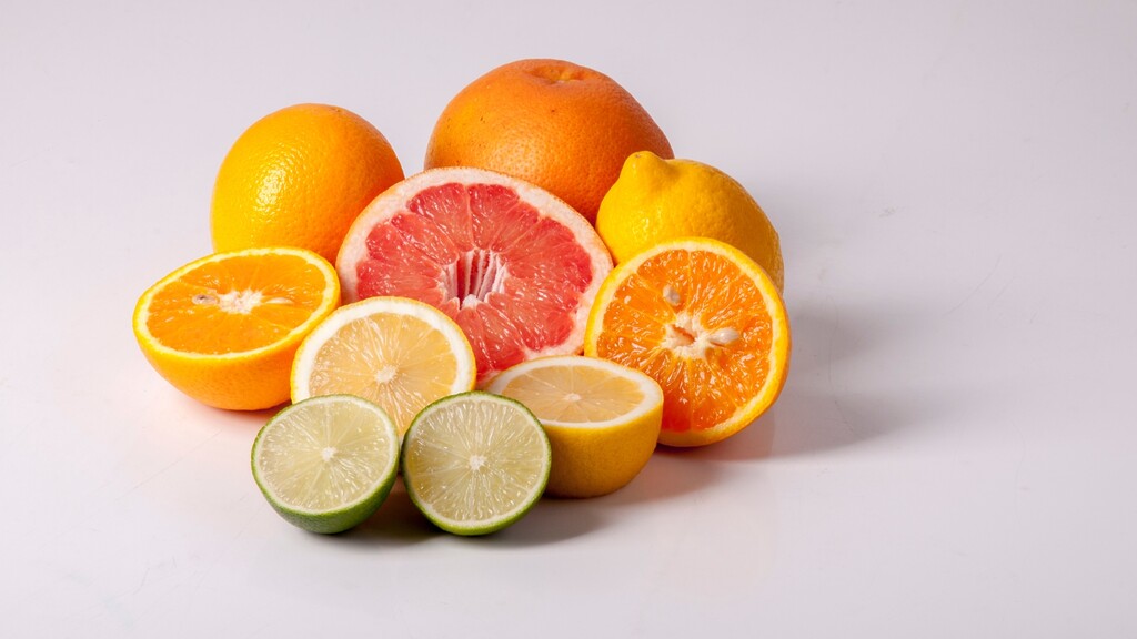Assorted citrus fruits, including oranges, grapefruit, lemons, and limes, arranged on a white background.