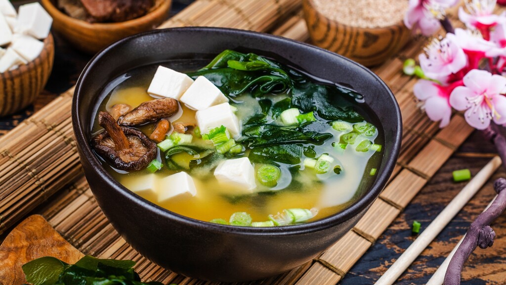 Bowl of miso soup with tofu, seaweed, mushrooms, and green onions.