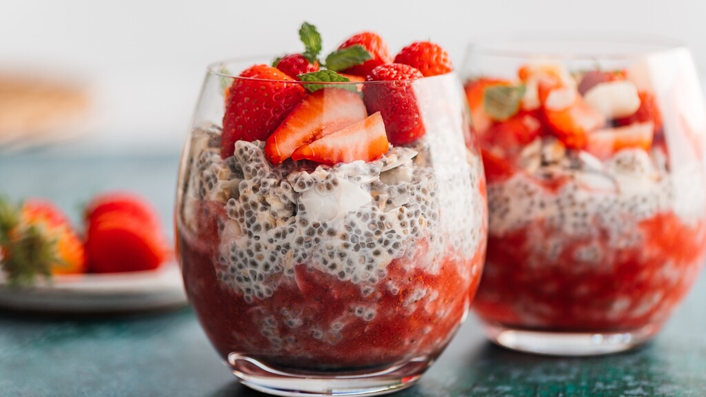 Strawberry chia pudding: Two glasses of chia pudding layered with strawberry puree and topped with fresh strawberries and mint.