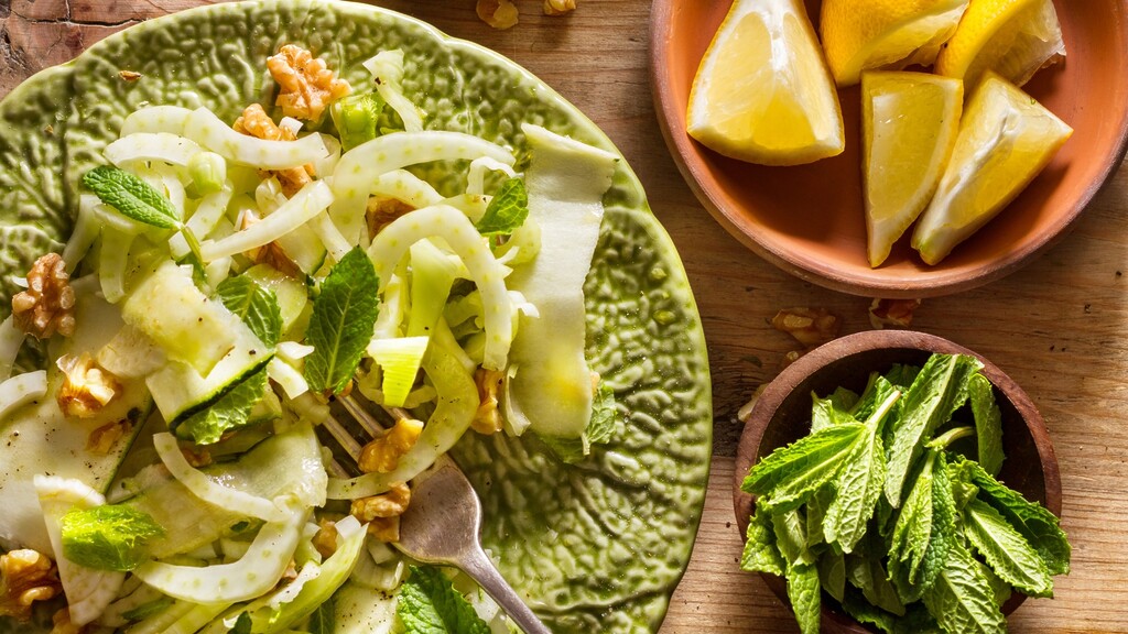 Fresh fennel and apple salad with walnuts, mint, and lemon wedges.