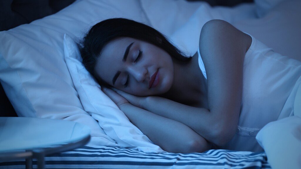 Woman sleeping peacefully in bed at night.