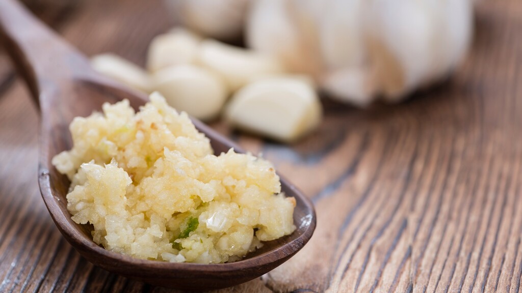 Minced garlic on a wooden spoon.