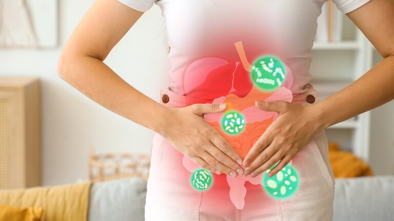Person holding their stomach with a glowing digestive system graphic overlay.