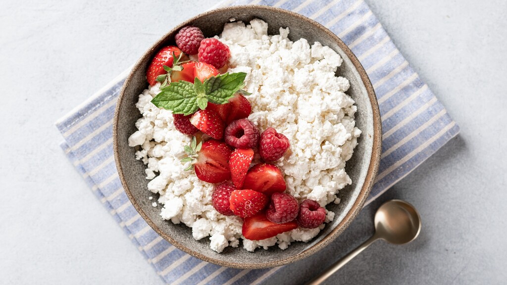 A small bowl of cottage cheese topped with fresh raspberries