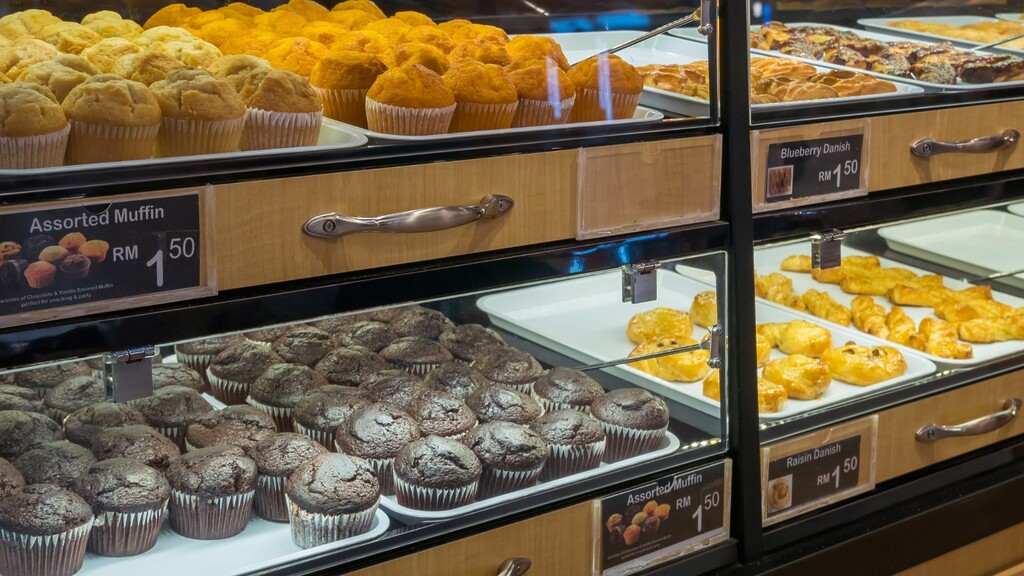 A bakery display case filled with muffins, pastries, and sweet baked goods.