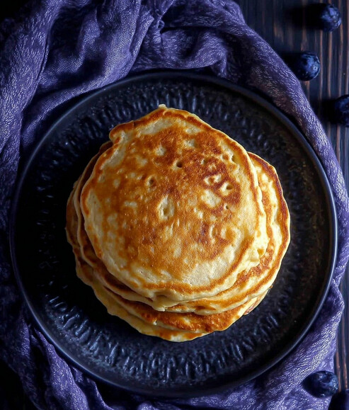 DASH-Friendly Protein Pancakes - stack of golden fluffy pancakes on a white plate ready for toppings
