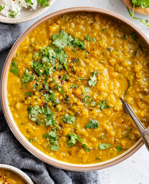DASH-Friendly Lentil Curry - thick, creamy yellow Indian dal garnished with fresh cilantro and a sprinkle of chili flakes ready to serve