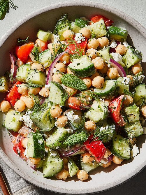 Mediterranean Chickpea Salad - vibrant bowl of chickpeas, cucumber, and red bell pepper topped with crumbled feta and fresh herbs, ready to serve