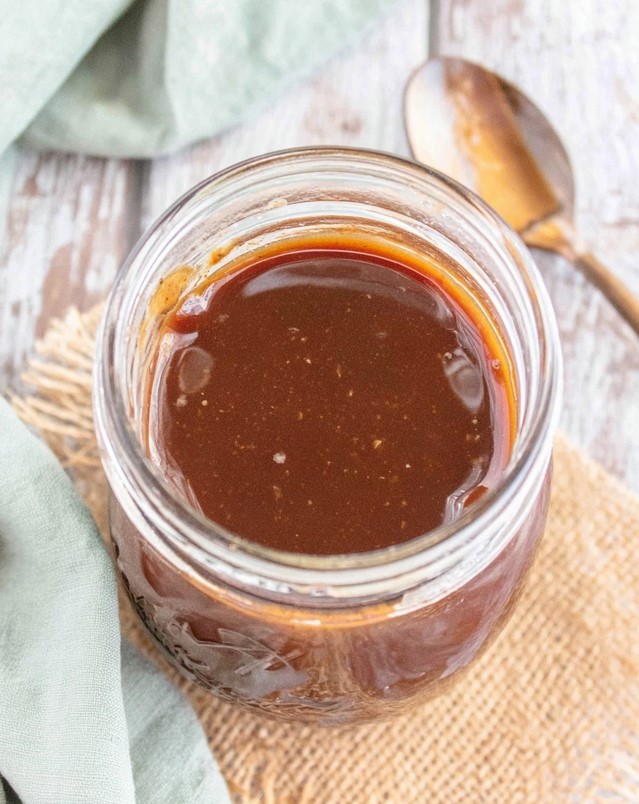 Sugar free balsamic vinaigrette - rich dark dressing stored in a glass mason jar on a kitchen counter